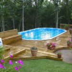 : above ground pool with deck and patio
